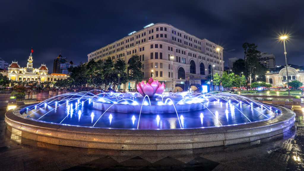 HO CHI MINH, VIETNAM - JULY 16,2022 : Beautiful fountain roundabout and hotel rex and chanel shop located inside, in the heart of Ho Chi Minh city.